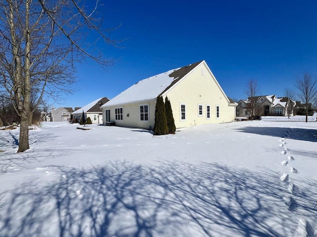 snow covered rear of property with a residential view