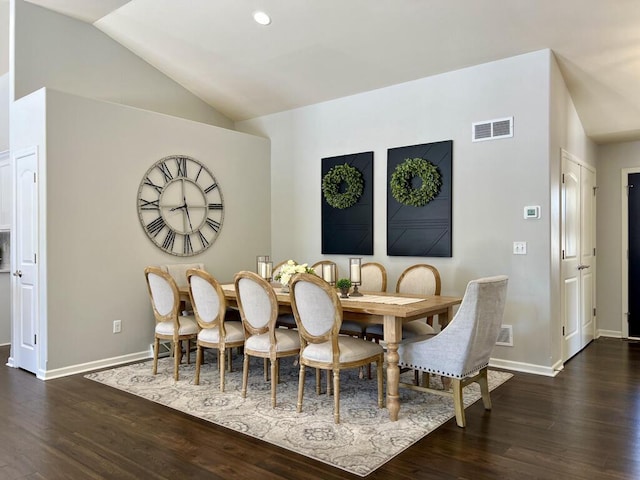 dining room featuring dark wood-style flooring, visible vents, vaulted ceiling, and baseboards