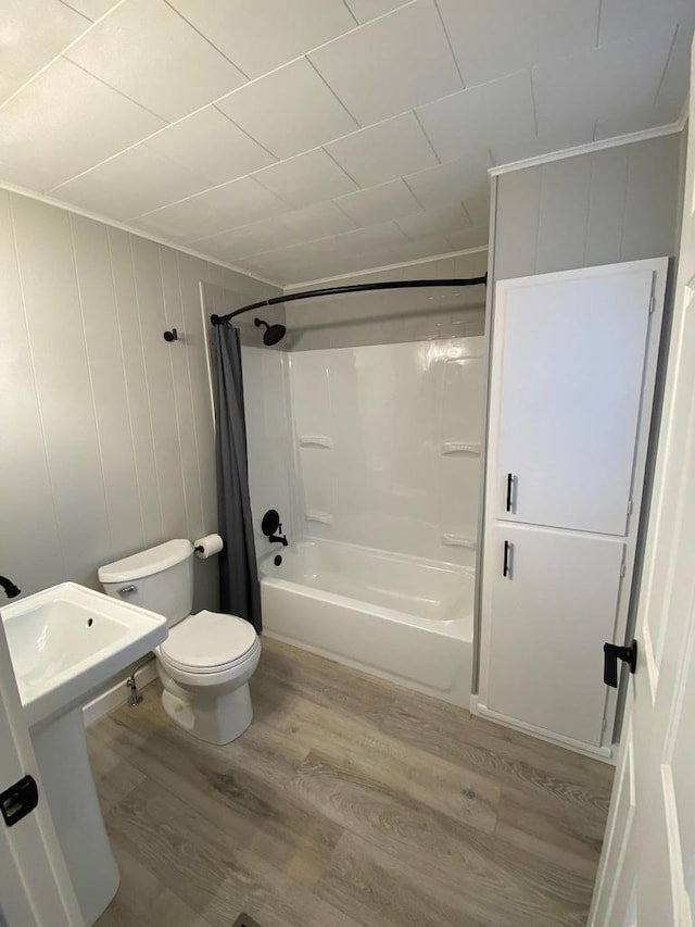 full bath with toilet, shower / bath combo, and wood finished floors