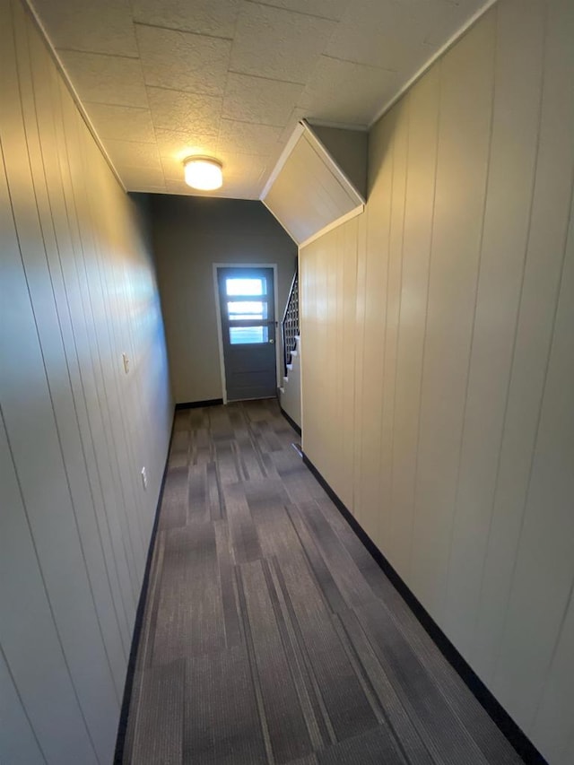 corridor with stairs and dark colored carpet