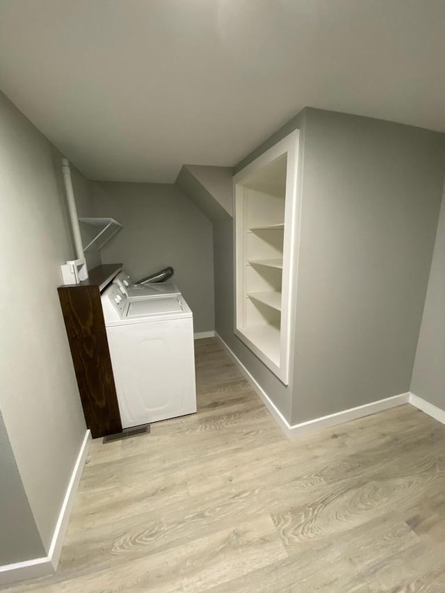 washroom with light wood-type flooring, baseboards, and washer and clothes dryer