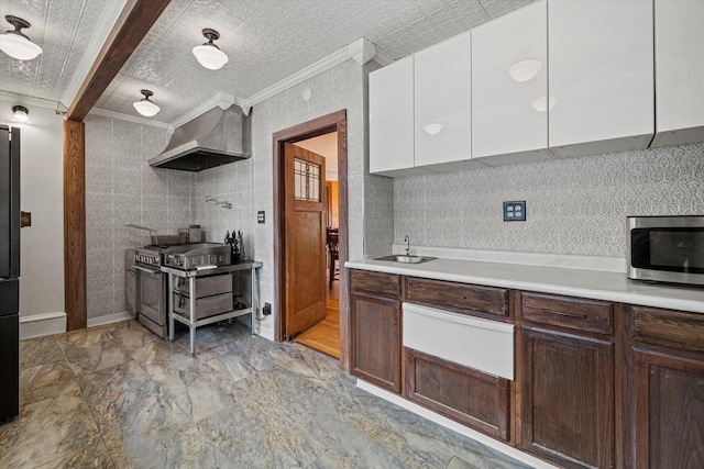 kitchen featuring wall chimney exhaust hood, appliances with stainless steel finishes, ornamental molding, light countertops, and white cabinetry