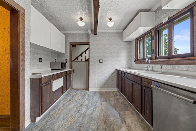 kitchen featuring stainless steel appliances, light countertops, a sink, and white cabinetry