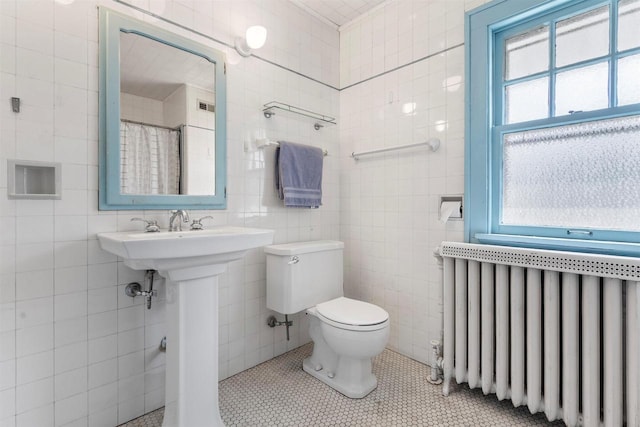 full bath featuring radiator, toilet, tile patterned floors, curtained shower, and tile walls