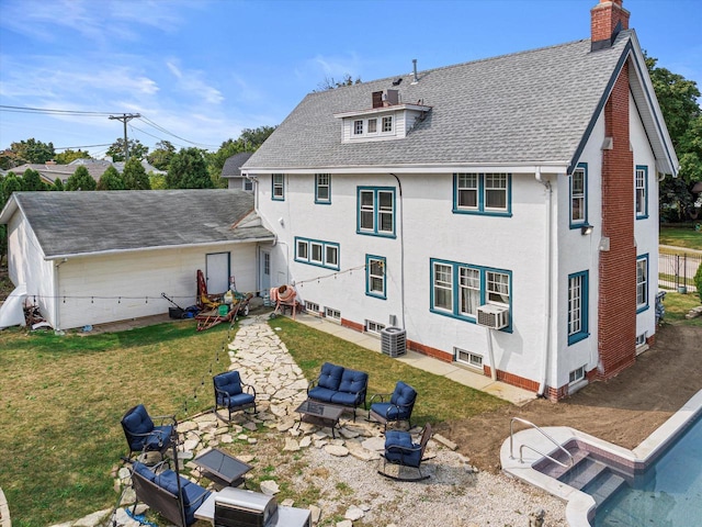 back of property with central AC unit, cooling unit, a yard, roof with shingles, and a chimney