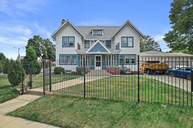 view of front of property with a balcony, a fenced front yard, a front lawn, and stucco siding