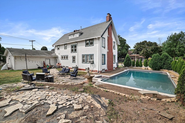 back of property with an outdoor pool, a patio, a chimney, cooling unit, and stucco siding