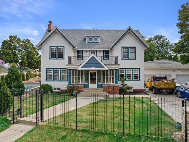 view of front of property featuring a garage, a front lawn, a fenced front yard, and stucco siding