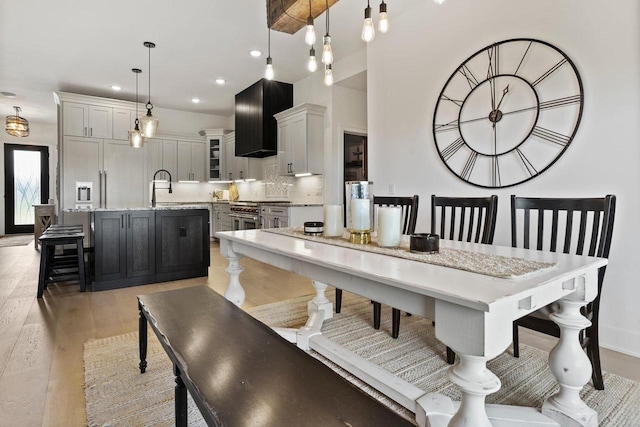 dining room with light wood-type flooring, baseboards, and recessed lighting