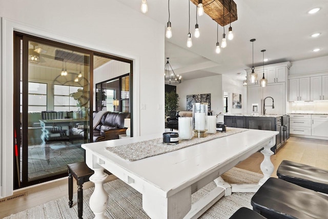 dining area with light wood-type flooring, an inviting chandelier, visible vents, and recessed lighting