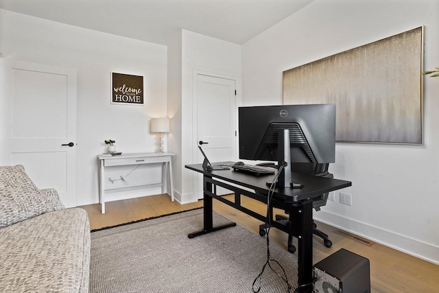 office featuring baseboards, visible vents, and wood finished floors