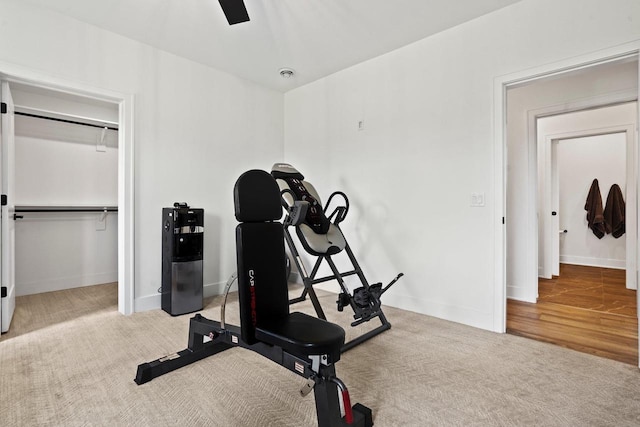 exercise area with light colored carpet and baseboards