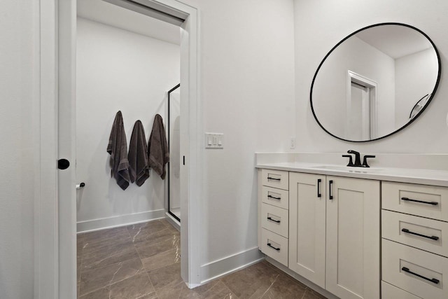 full bathroom featuring a stall shower, vanity, and baseboards