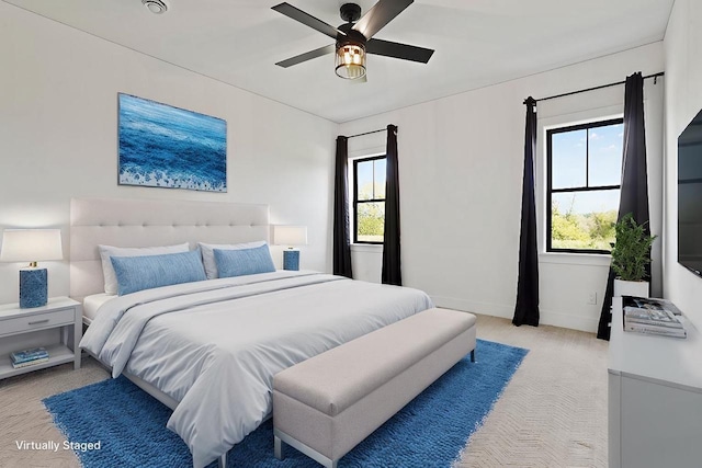 bedroom with light carpet, ceiling fan, and baseboards