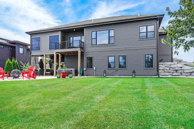 back of house featuring an outdoor fire pit, a lawn, a patio area, and a balcony