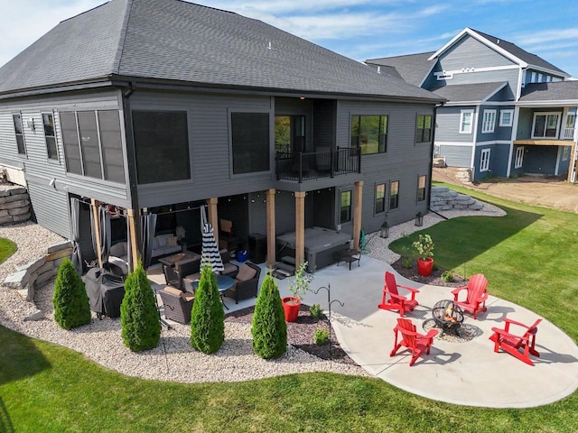 back of property with a patio area, an outdoor fire pit, roof with shingles, and a yard