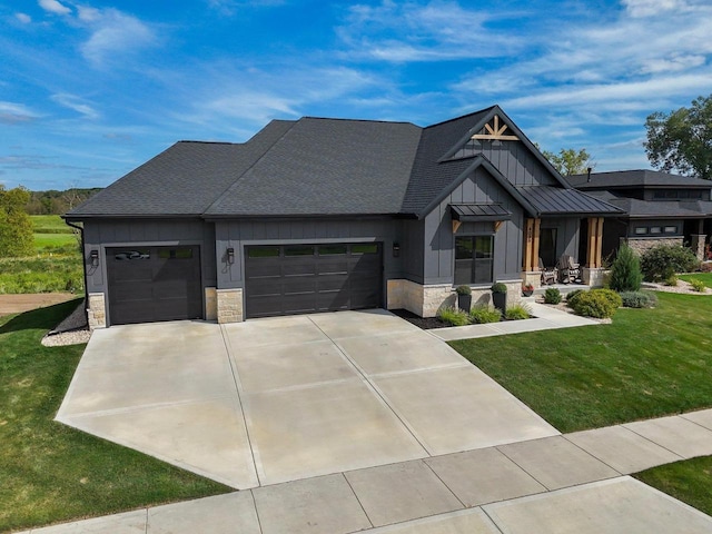 view of front of house with an attached garage, stone siding, concrete driveway, board and batten siding, and a front yard