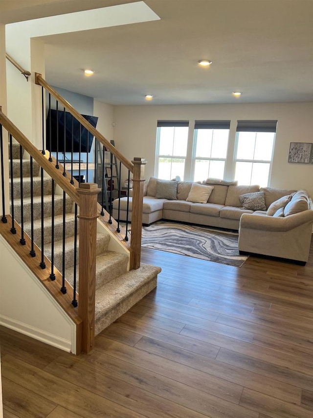 living area featuring stairs, recessed lighting, plenty of natural light, and wood finished floors