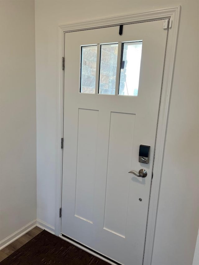 doorway to outside with dark wood finished floors and baseboards