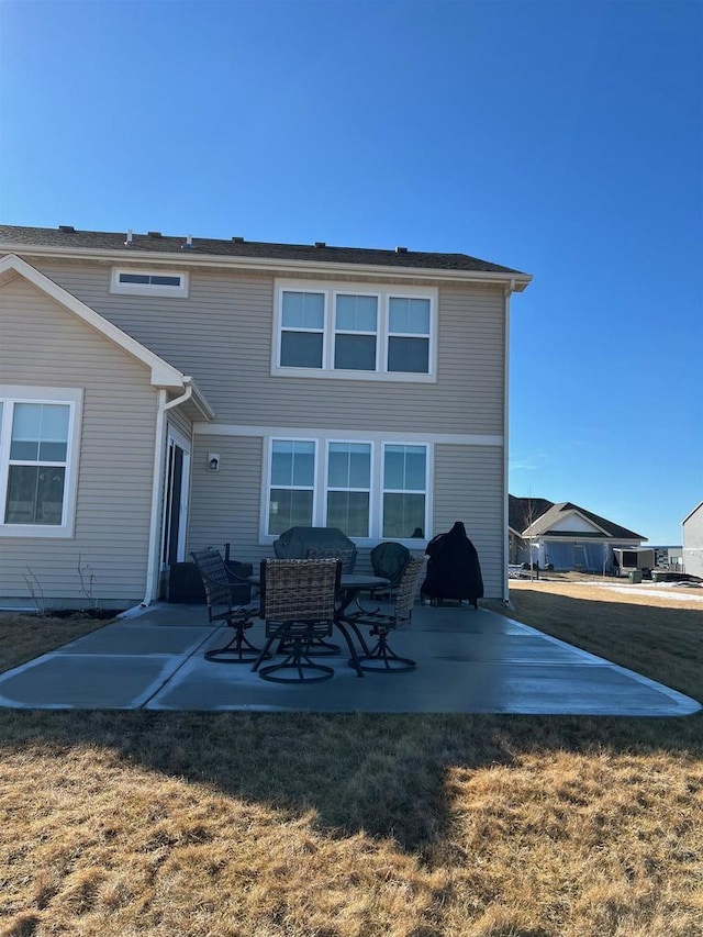 back of property featuring a yard and a patio