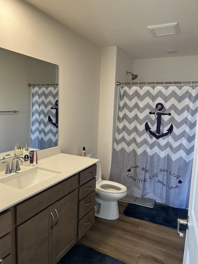 bathroom featuring a shower with curtain, vanity, toilet, and wood finished floors