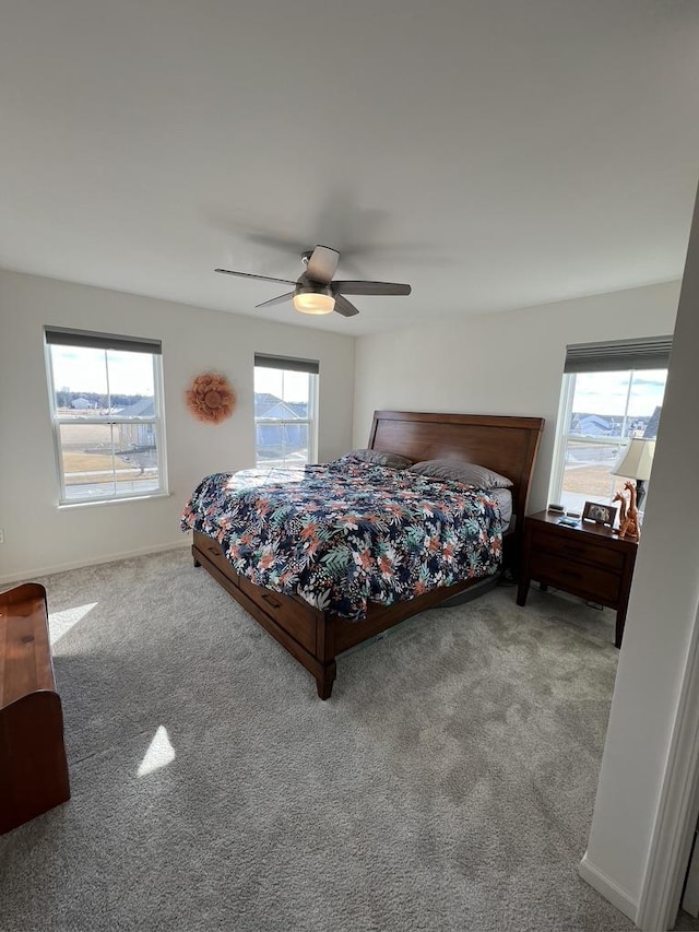 bedroom featuring a ceiling fan, carpet flooring, baseboards, and multiple windows