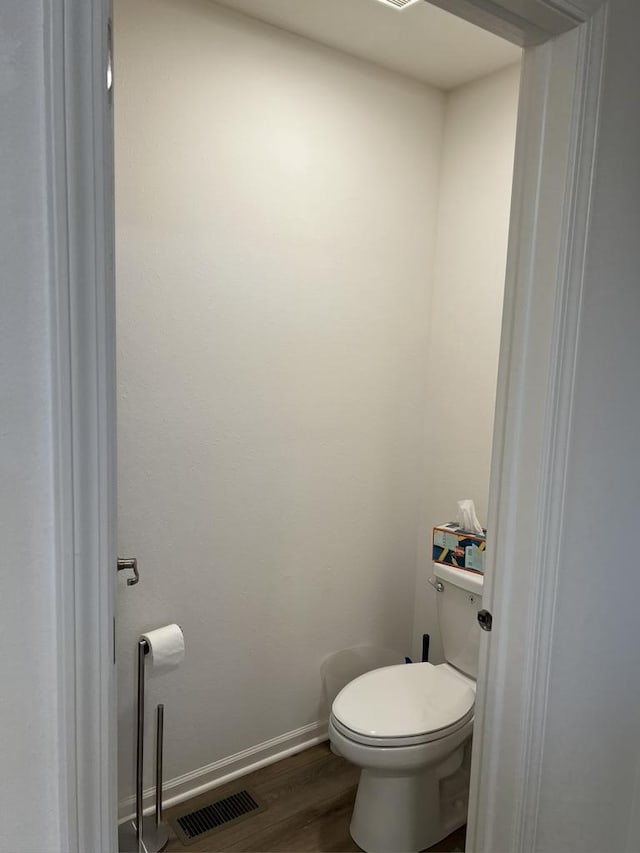 bathroom with visible vents, wood finished floors, toilet, and baseboards