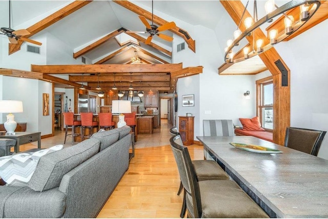 dining area with high vaulted ceiling, visible vents, ceiling fan, and light wood-style flooring