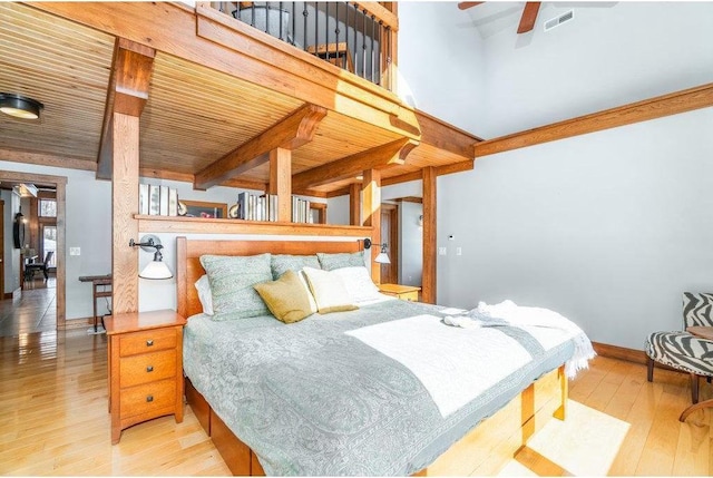 bedroom with baseboards, visible vents, wooden ceiling, beamed ceiling, and light wood-type flooring