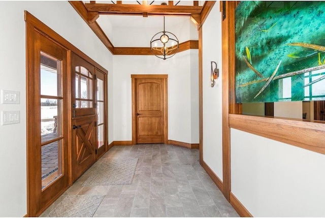 foyer featuring baseboards and a chandelier