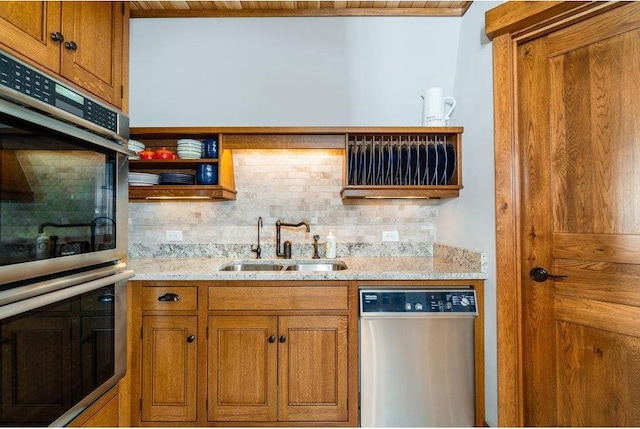 kitchen featuring stainless steel appliances, brown cabinets, a sink, and decorative backsplash