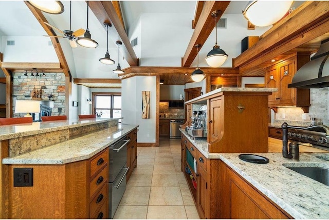 kitchen with light stone counters, a center island, pendant lighting, and a sink