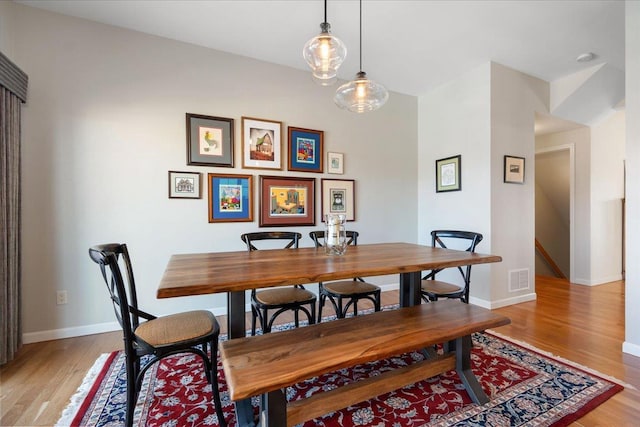 dining area featuring baseboards, visible vents, and light wood-style floors