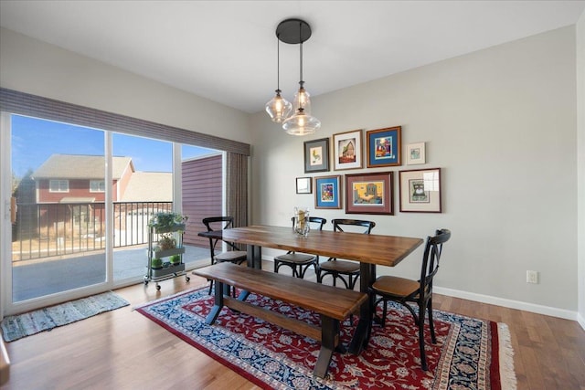 dining space with baseboards and wood finished floors