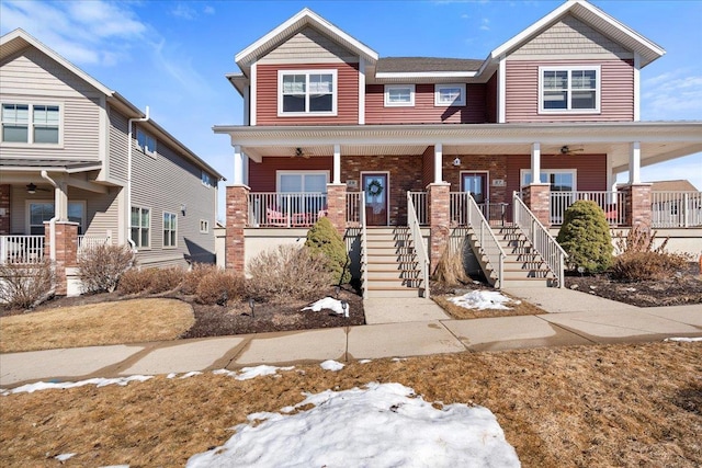 view of front of home with covered porch, brick siding, and stairs