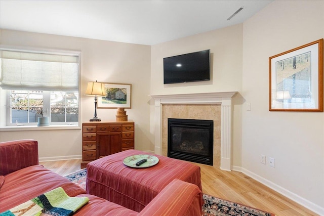 interior space with light wood finished floors, a fireplace, visible vents, and baseboards