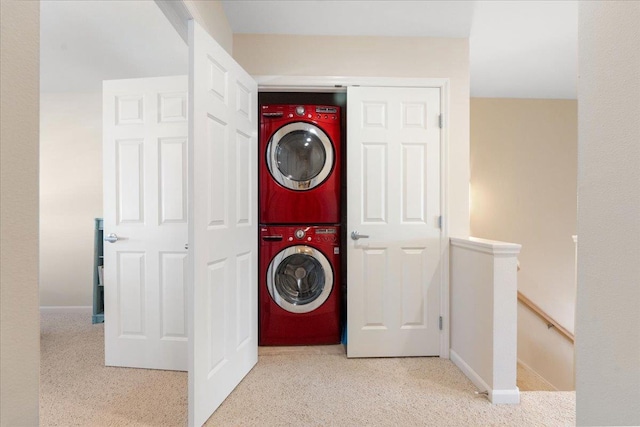 washroom with stacked washer and dryer, laundry area, and baseboards