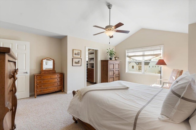 bedroom featuring baseboards, ceiling fan, a spacious closet, vaulted ceiling, and carpet flooring