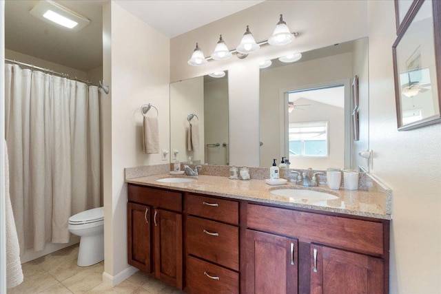 full bath featuring double vanity, a sink, toilet, and tile patterned floors