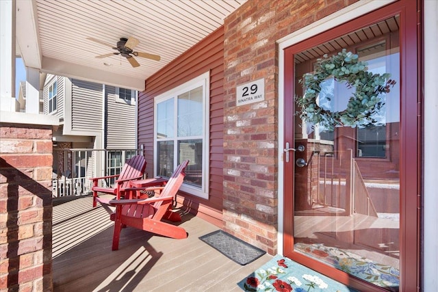 wooden terrace featuring covered porch and ceiling fan