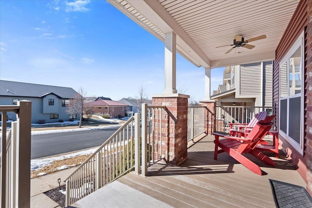 deck with a residential view and a ceiling fan