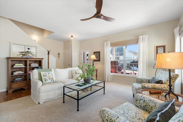 living room featuring ceiling fan, carpet, and baseboards