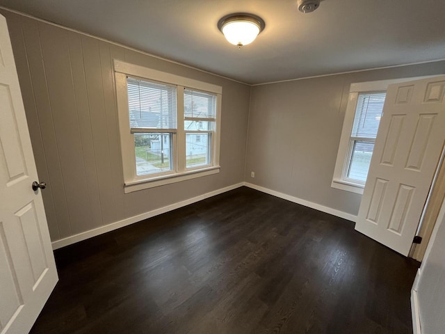 unfurnished bedroom with dark wood-style floors and baseboards