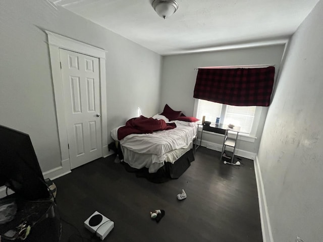 bedroom featuring dark wood-style floors and baseboards