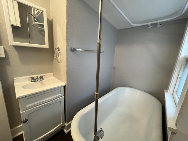 bathroom featuring a soaking tub and vanity