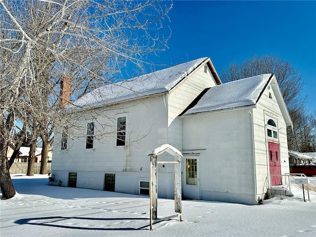 snow covered property featuring concrete block siding