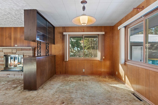 kitchen featuring carpet floors, wood walls, and visible vents