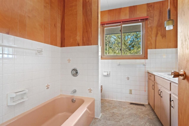 bathroom with a bathtub, visible vents, tile walls, and vanity