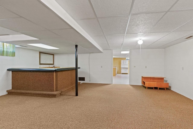 bar with concrete block wall, carpet flooring, and a drop ceiling