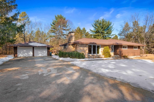 ranch-style house with an outbuilding, a chimney, and a garage